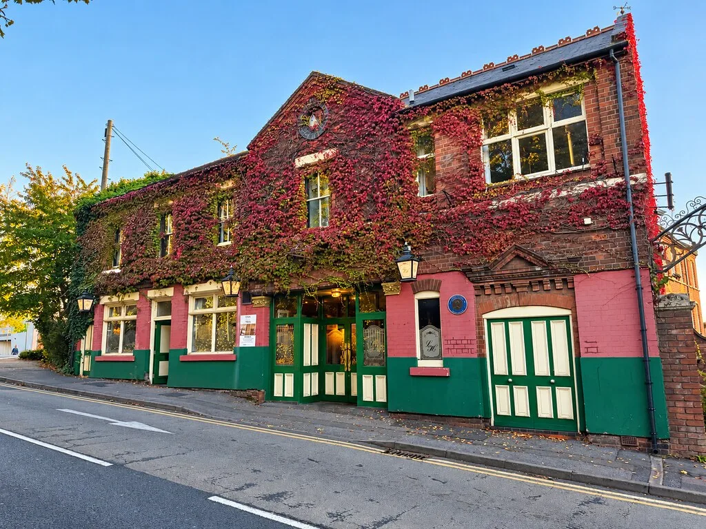 The Lyndon House Hotel in Walsall, a brick building covered in red creeper with a green and pink painted ground floor