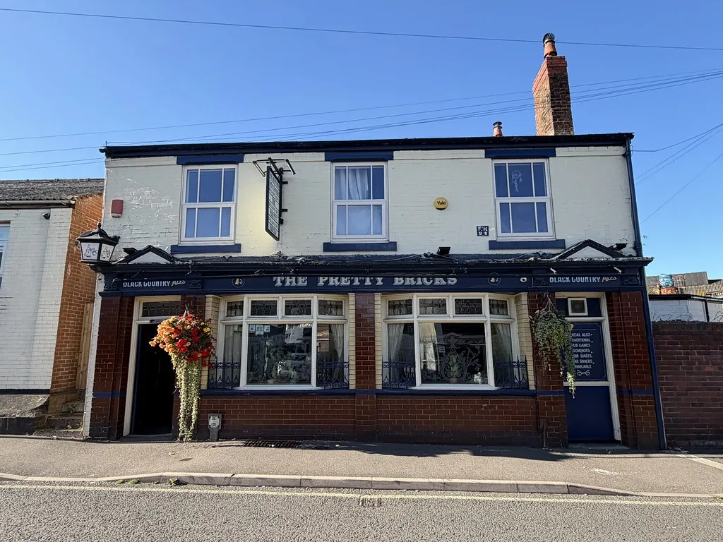 The Pretty Bricks in Walsall, a two-storey back-street pub with a dark tiled frontage and white upper floor